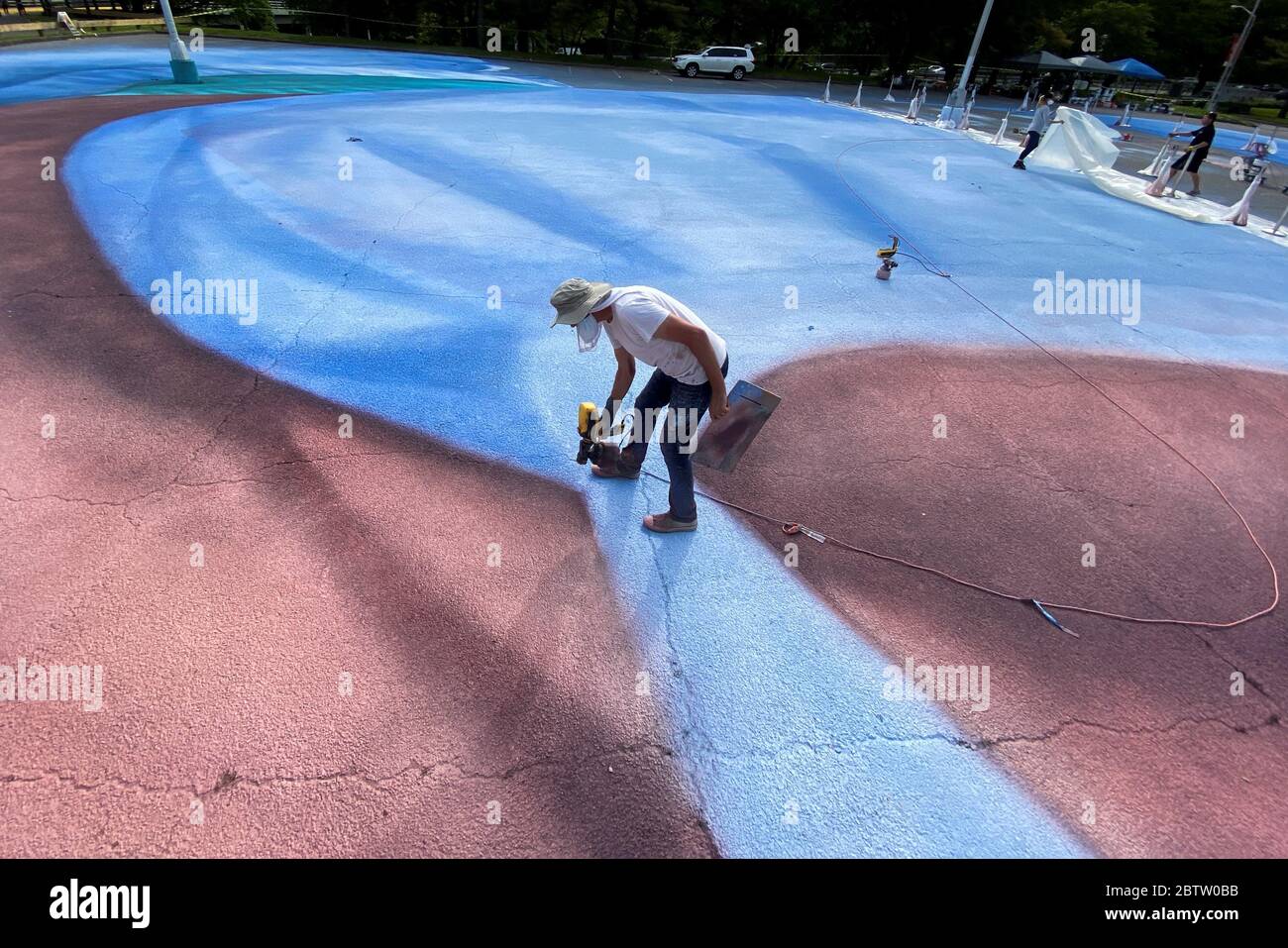 Nueva York, Estados Unidos. 27th May, 2020. Cuban artist Jorge Rodriguez Gerada works on a portrait of late Dominican physician Ydelfonso Decoo, at the parking lot of Queens Museum in New York, USA, 27 May 2020. Ydelfonso Decoo died due the COVID-19. Credit: Kena Betancur/EFE/Alamy Live News Stock Photo