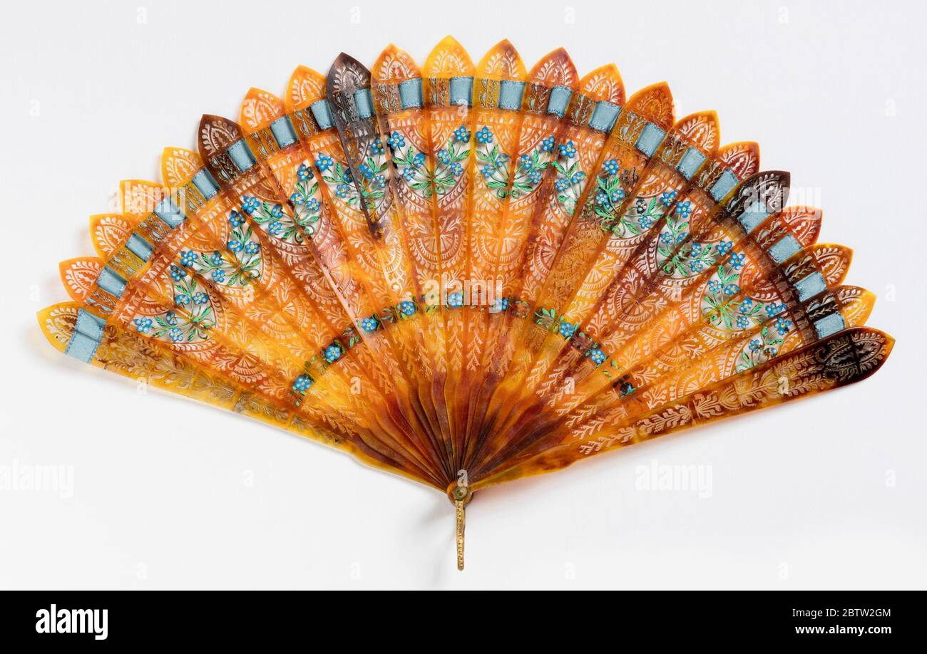 Bris fan. Research in ProgressBrisé fan. Brown tortoise shell sticks pierced in flat openwork all-over design. Painted with gouache showing forget-me-nots and sprays of flowers. Blue connecting ribbon. Stock Photo