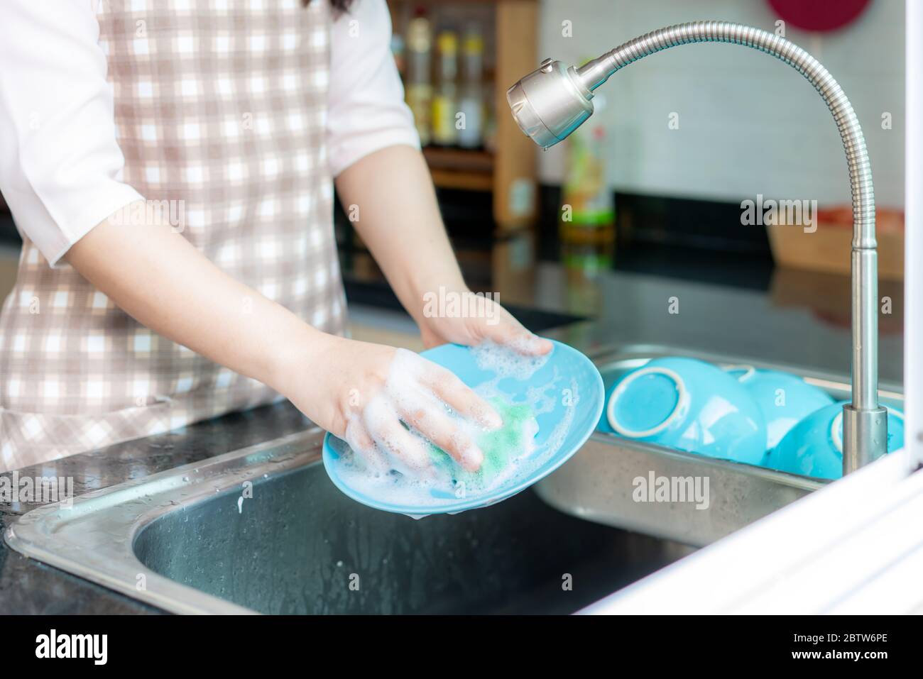 Woman washing her clothes in the kitchen sink domestic chores Stock Photo -  Alamy