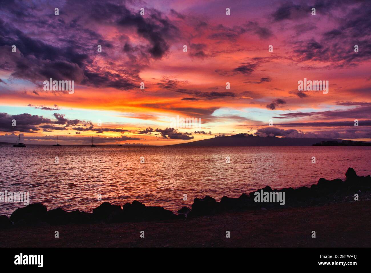 Amazing fiery sunset from the shores of Maui out to the nearby islands of Lanai and Molokai. Stock Photo