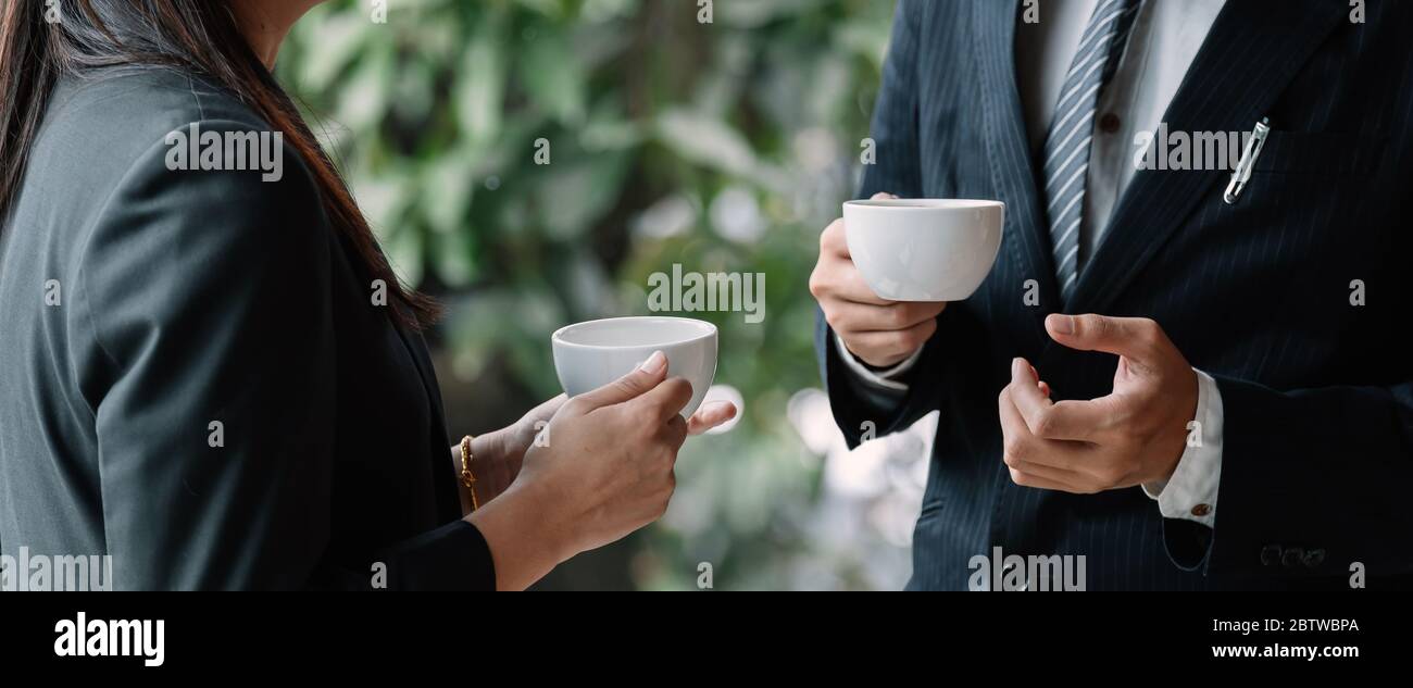 Coffee break. Group business people, standing in modern office, holding