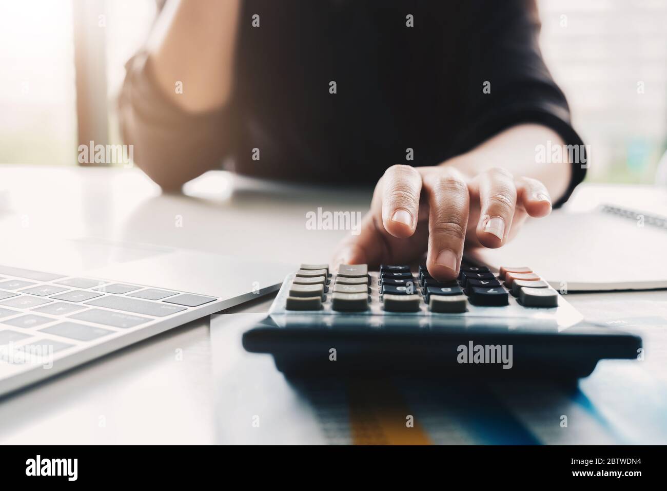 Close up Business woman using calculator and laptop for do math finance Stock Photo