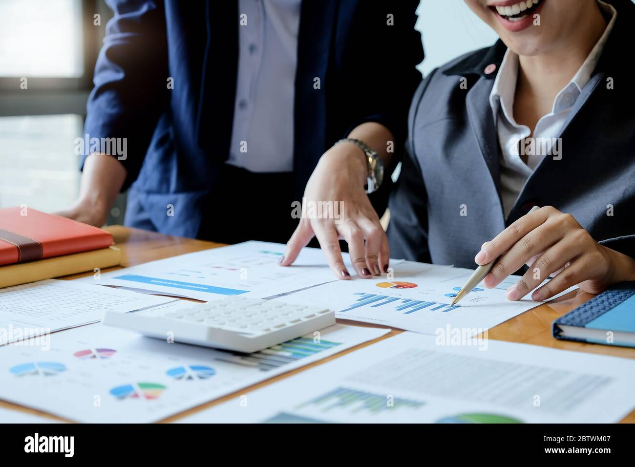 Group of businesswoman discussing on stock market charts in office Stock Photo