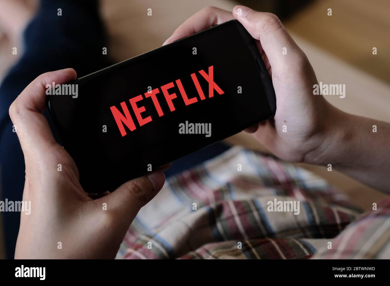 CHIANG MAI, THAILAND, MAR 29, 2020: Woman hand holding Smart Phone with Netflix logo on Apple iPhone Xs at home. Stock Photo