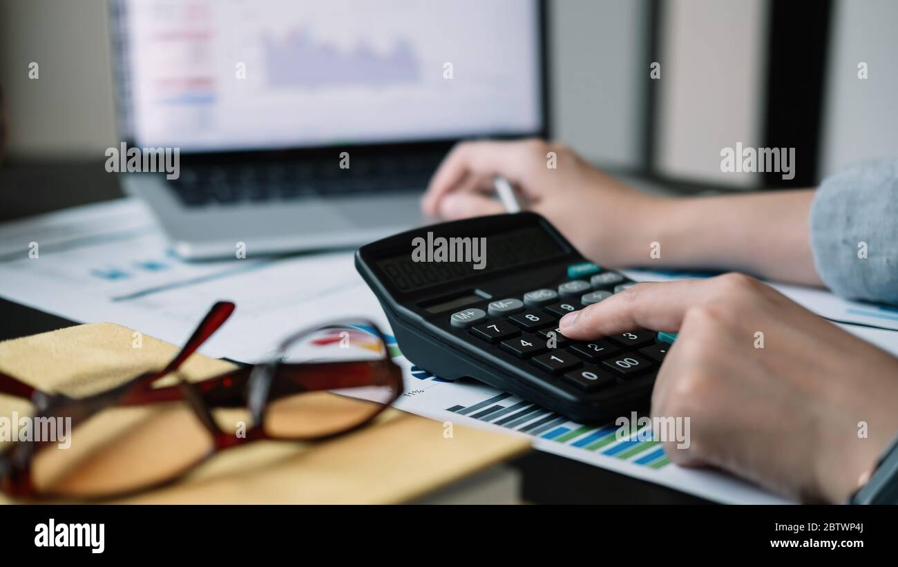 Business woman calculator and laptop for calculating finance, tax, accounting, statistics and analytic research concept Stock Photo