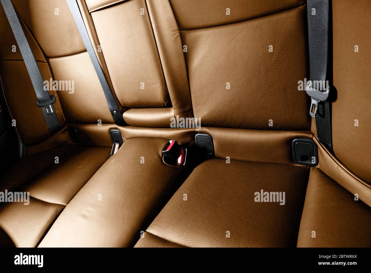 Back passenger brown seats in modern luxury car. Orange perforated