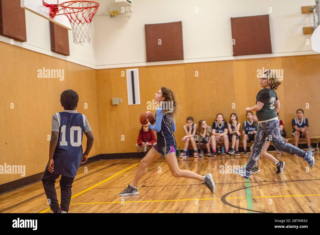 Mixed basketball action of boys and girls 8 to 10 years old, in a game. Stock Photo