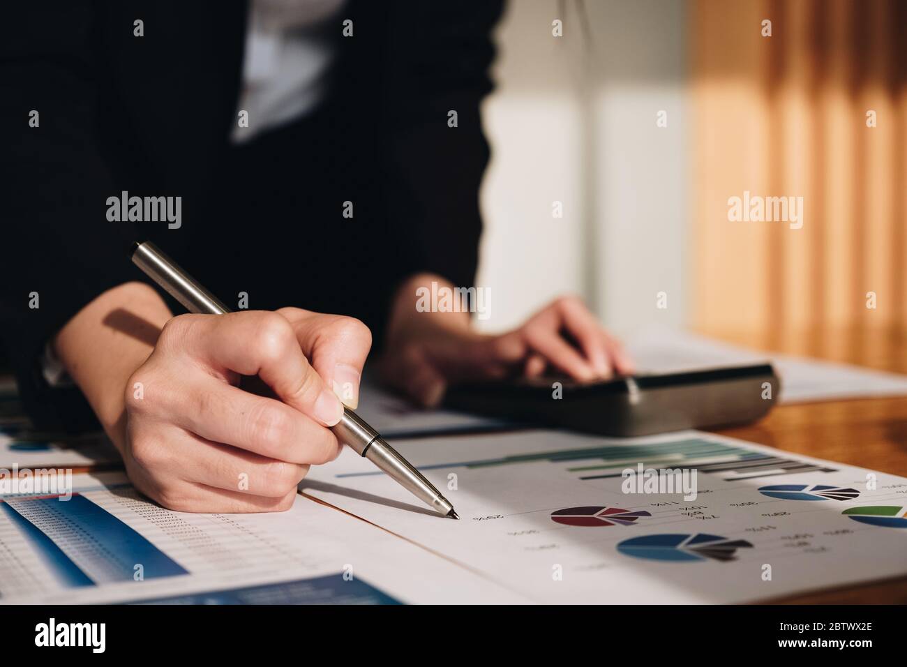 Close up Business woman using calculator for do math finance on wooden desk Stock Photo