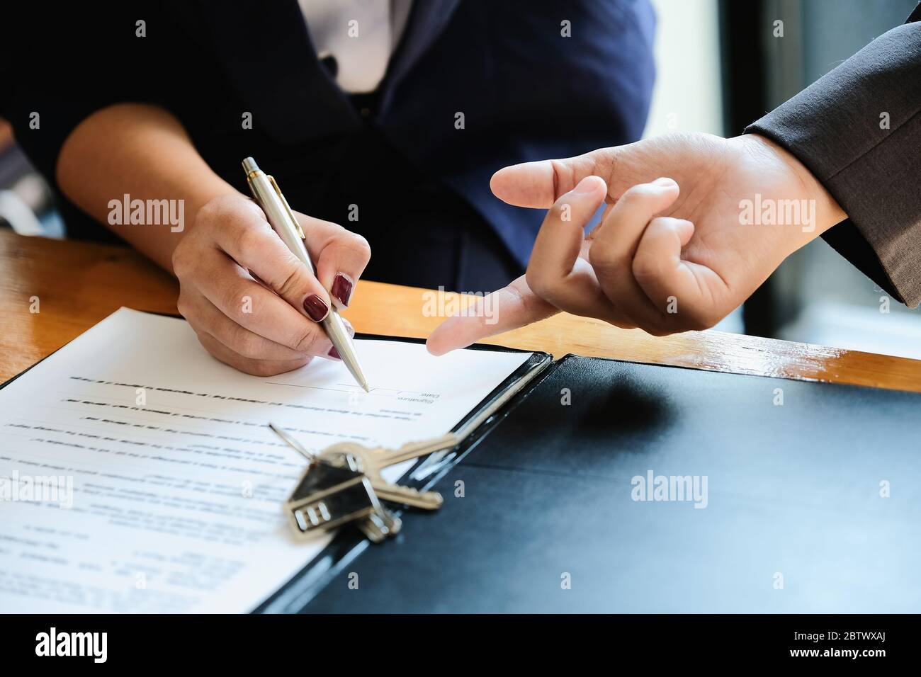 Real estate agent offer hand for customer sign agreement contract signature for buy or sell house. Stock Photo