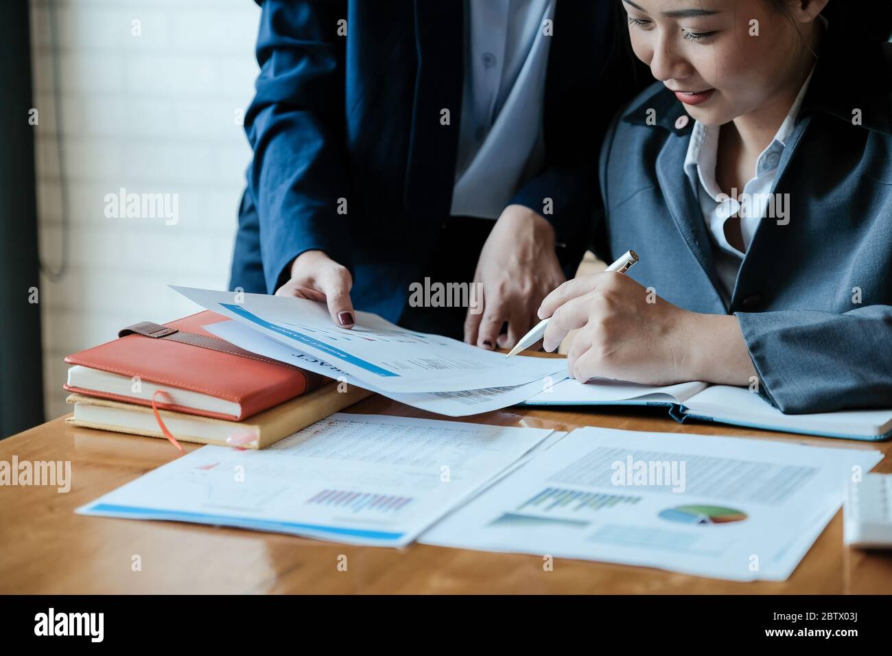 Close up of business people analyzing data from financial documents while working in the office Stock Photo