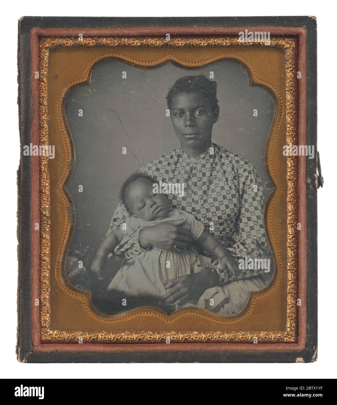 Daguerreotype of a woman with a child on her lap. Daguerreotype of a woman wearing a floral checked patterned blouse. The woman looks straight ahead at the camera and holds a baby on her lap. The baby wears a dress with a light colored dot pattern. The portrait is in front of a plain grey background. Stock Photo