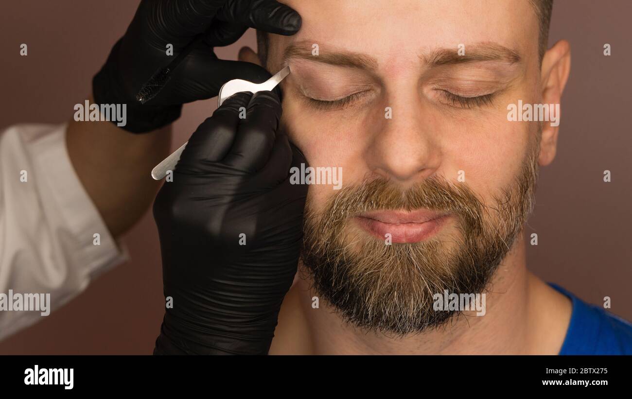 Professional barber doing threading procedure and correcting shape of