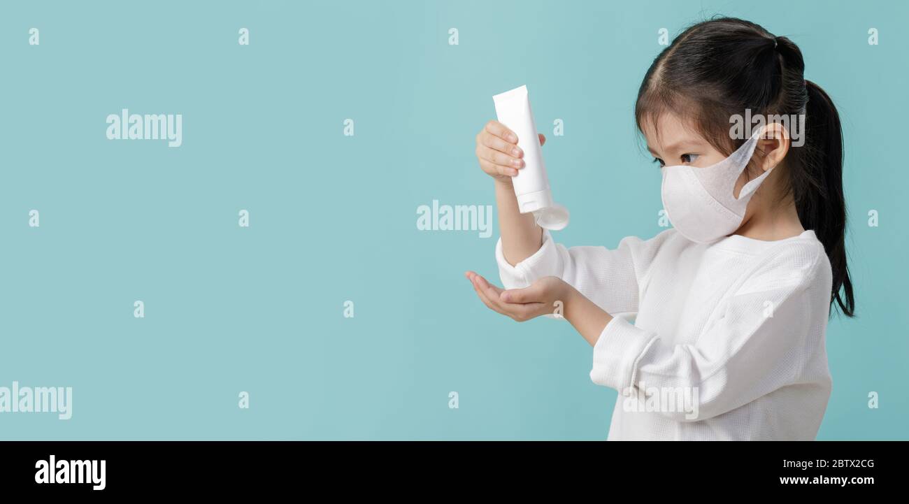 Asian little child girl wearing respirator mask to protect coronavirus outbreak and washing hands with alcohol gel, New virus Covid-19 from Wuhan Chin Stock Photo