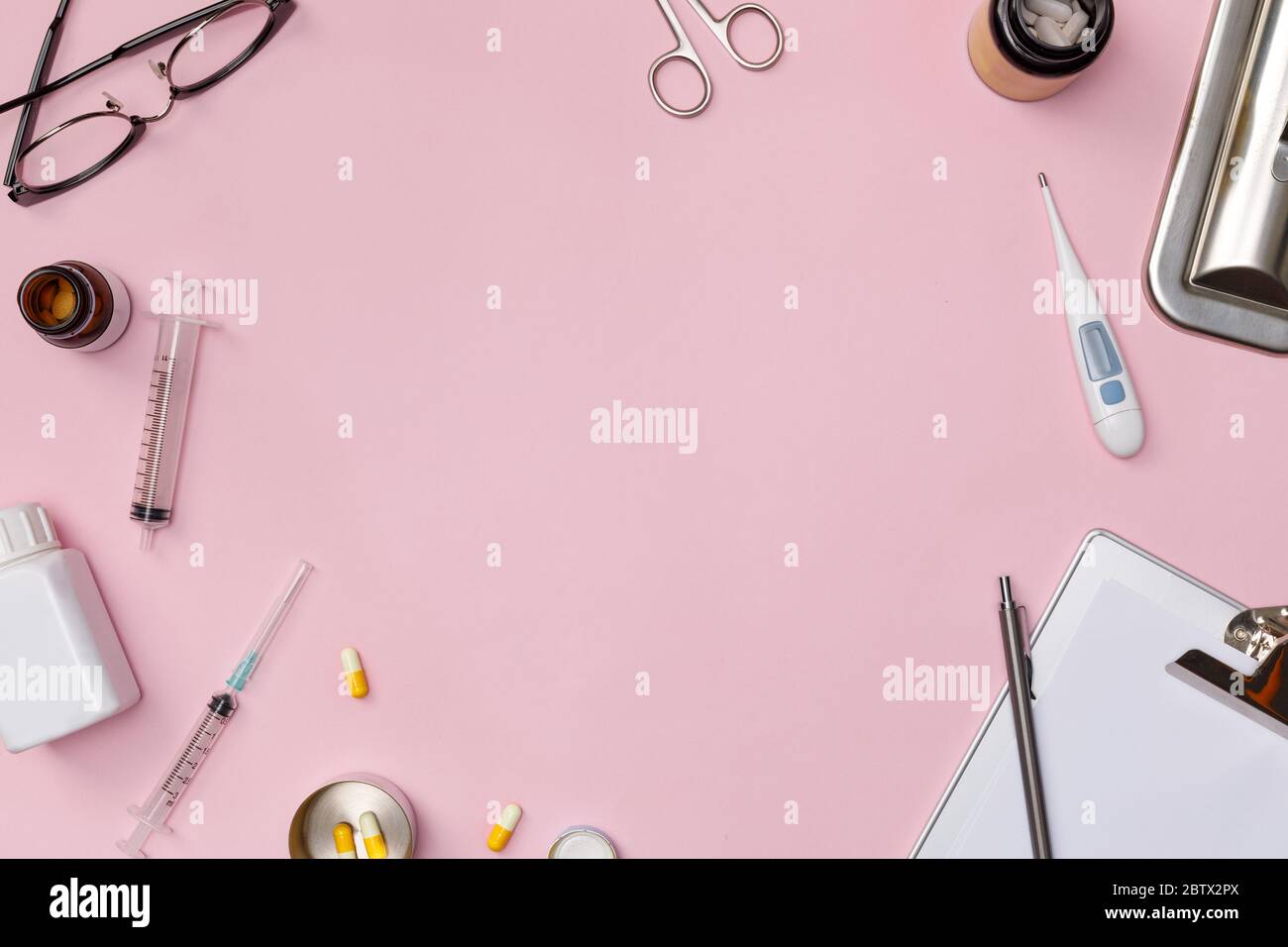 Creative flatlay of doctor medical equipment pink table with stethoscope, medical documents, thermometer, syringe and pills, Health care concept, Top Stock Photo