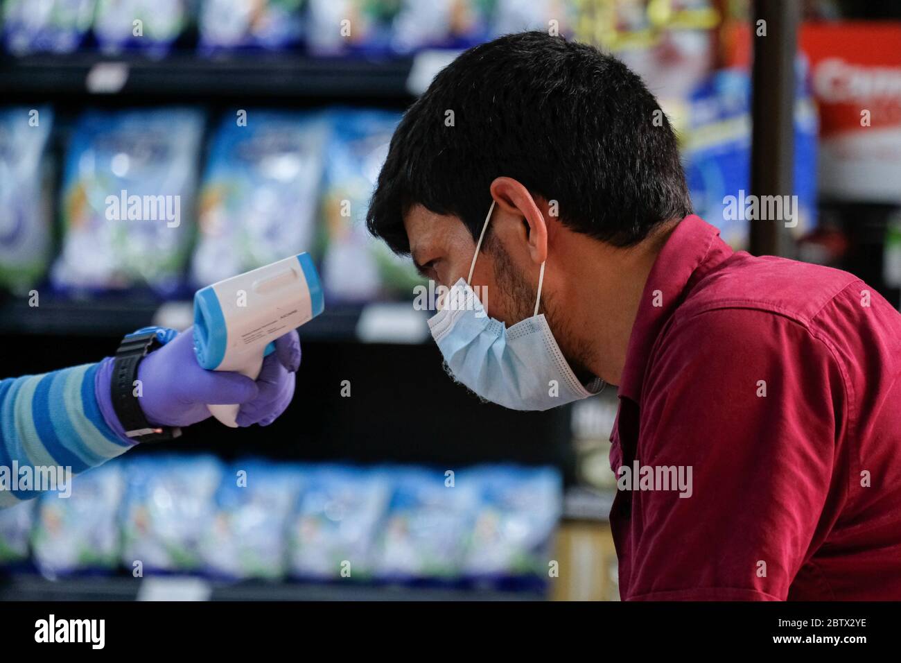 Kuala Lumpur, Malaysia. 27th May, 2020. A visitor seen having a temperature reading by a security guard before enter a shop during the movement control order at Kuala Lumpur. Malaysia had confirmed 15 new positive cases of Coronavirus on Wednesday and it is the lowest cases since the pandemic had started. Total of the pandemic cases are now up to 7619 and the total for recovered cases were 6083. Kuala Lumpur still have the most highly cases with the total 1987 cases. Credit: SOPA Images Limited/Alamy Live News Stock Photo