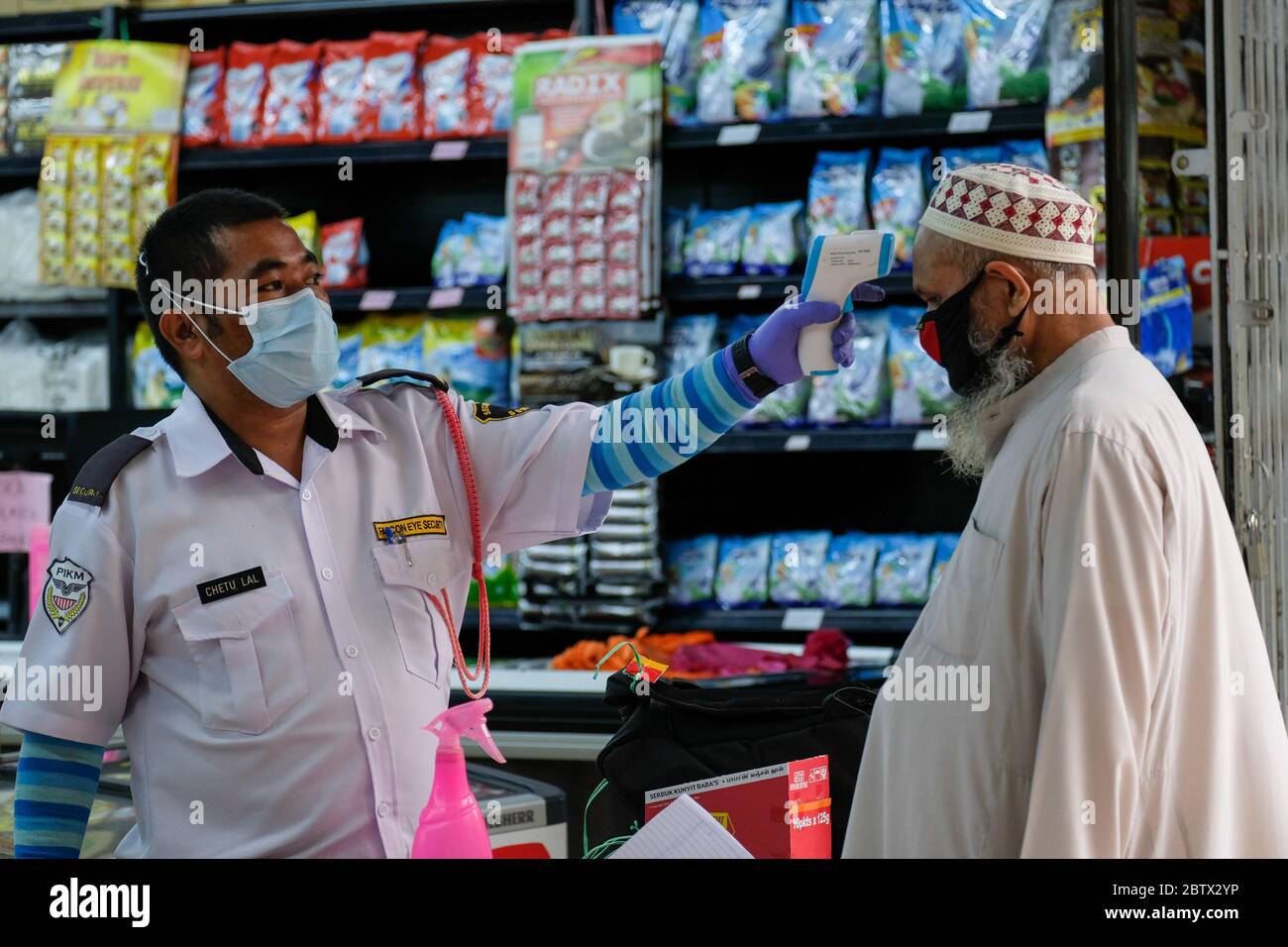 Kuala Lumpur, Malaysia. 27th May, 2020. A visitor seen having a temperature reading by a security guard before enter a shop during the movement control order at Kuala Lumpur. Malaysia had confirmed 15 new positive cases of Coronavirus on Wednesday and it is the lowest cases since the pandemic had started. Total of the pandemic cases are now up to 7619 and the total for recovered cases were 6083. Kuala Lumpur still have the most highly cases with the total 1987 cases. Credit: SOPA Images Limited/Alamy Live News Stock Photo