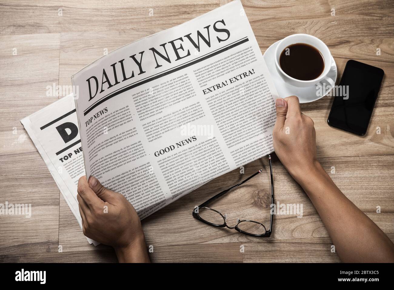 Hands holding the Business Newspaper on wooden table, Daily Newspaper mock-up concept Stock Photo