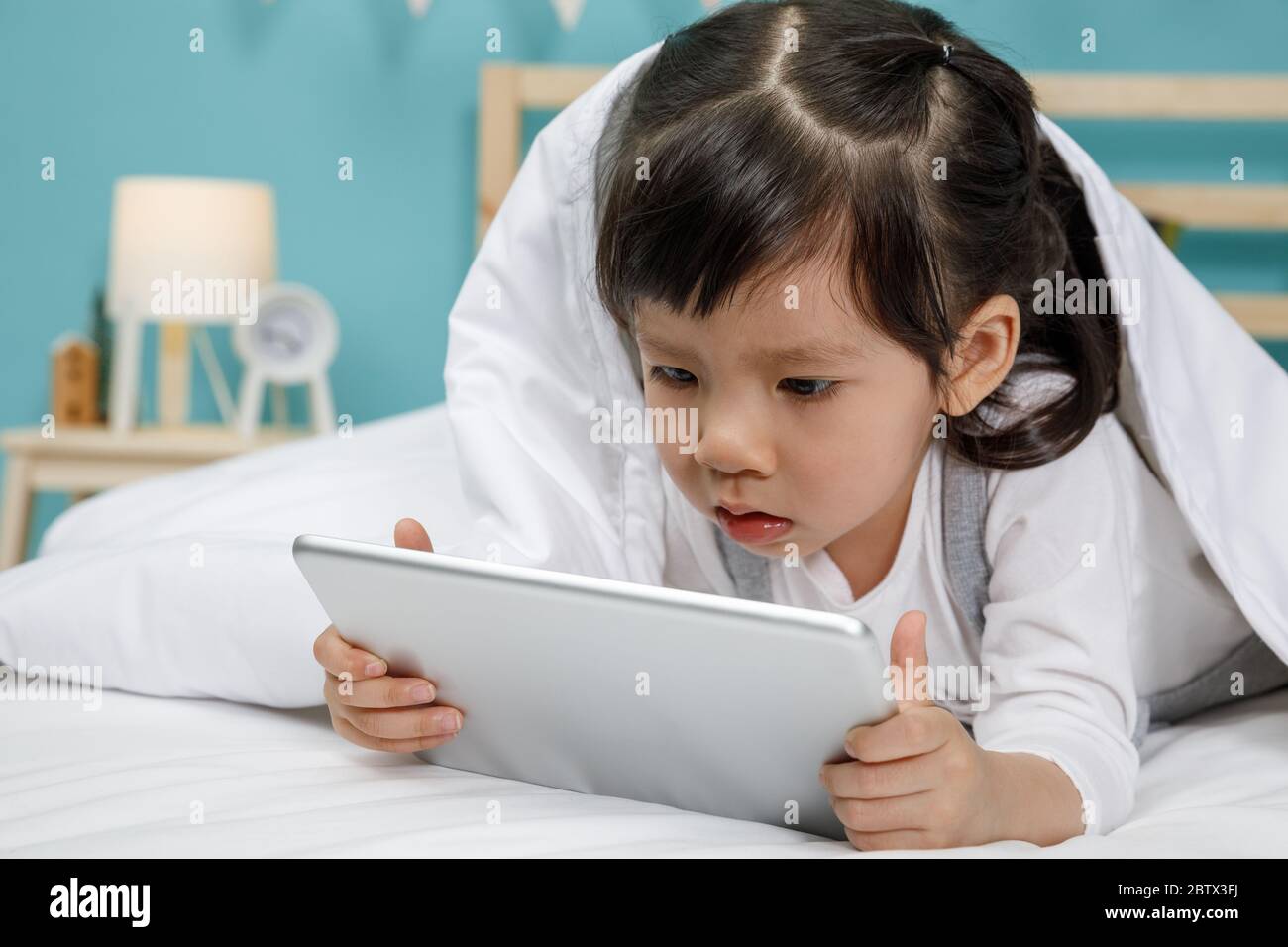 Little girl baby on the bed in the room hires stock photography and