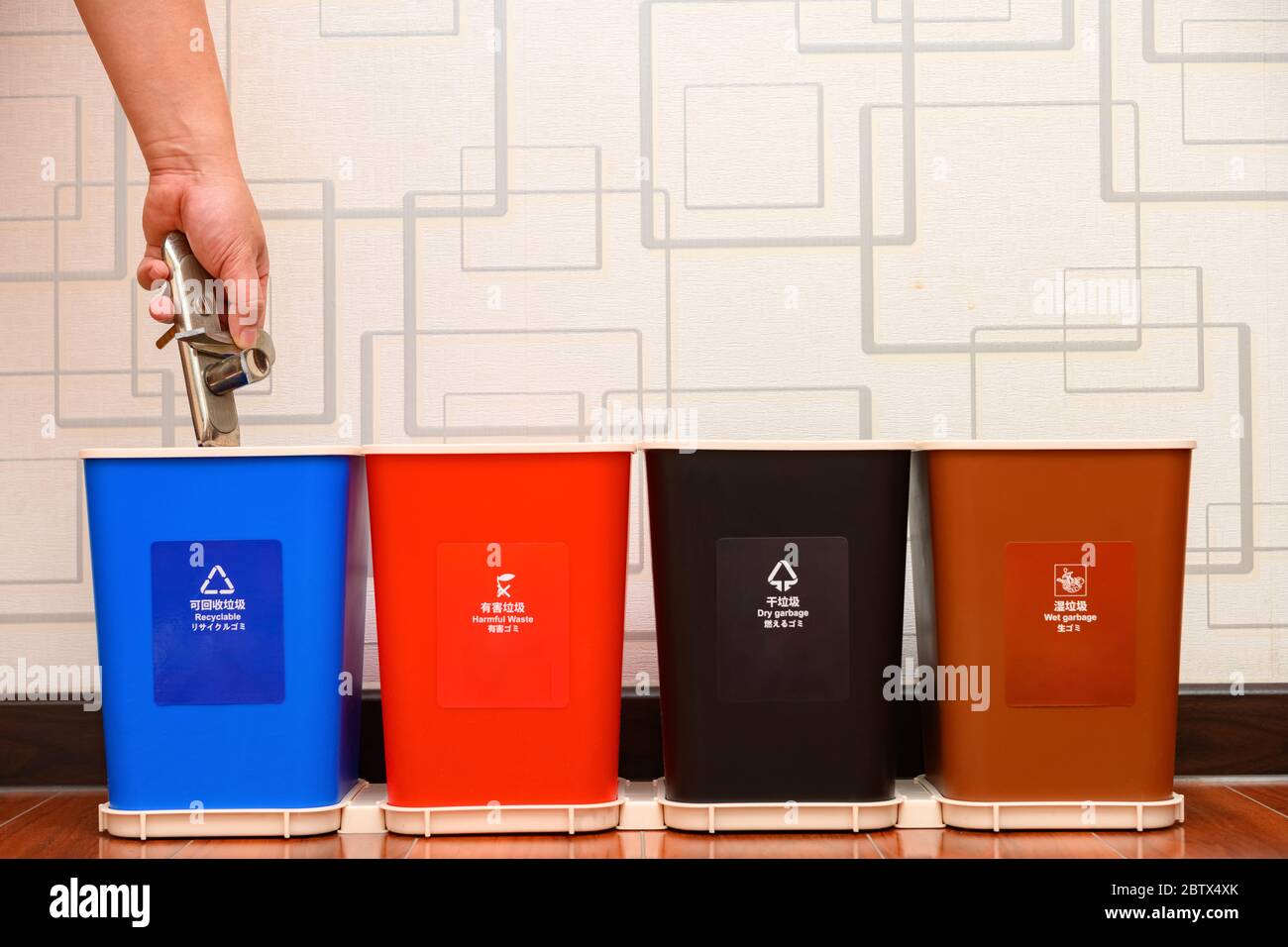 putting broken metal lock to a recyclable garbage bin English