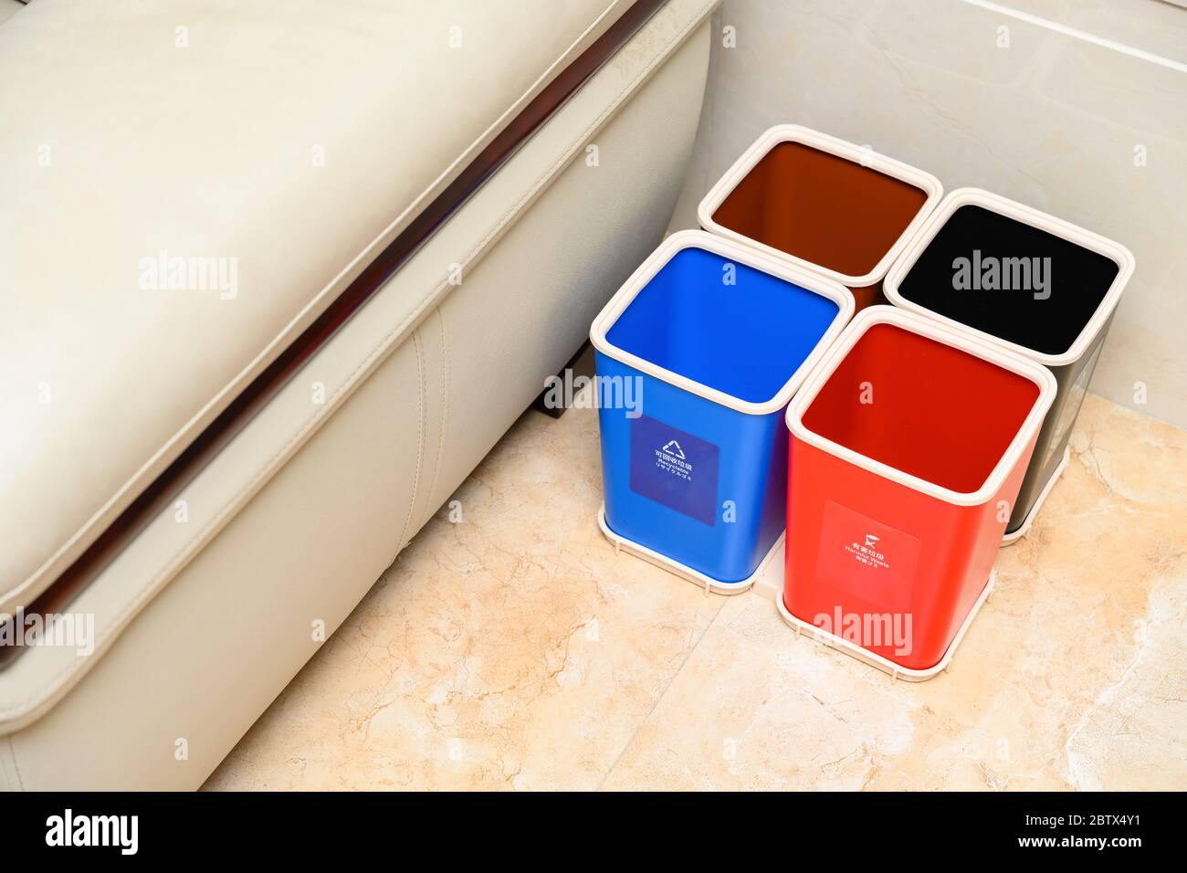 garbage classification bins near a sofa in a parlour at home English