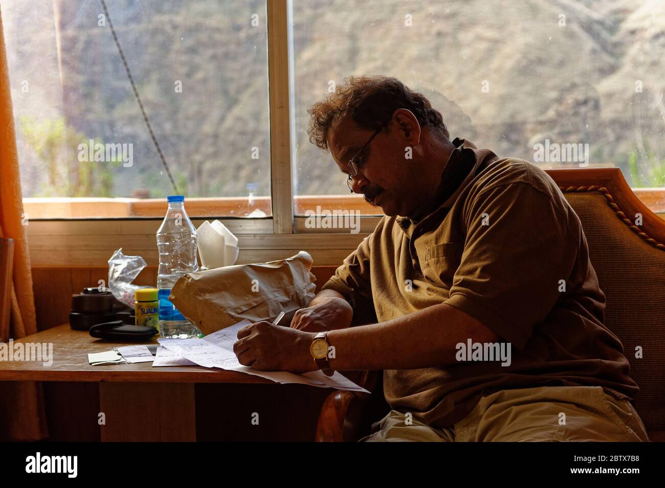 Man writing with pen near window Stock Photo