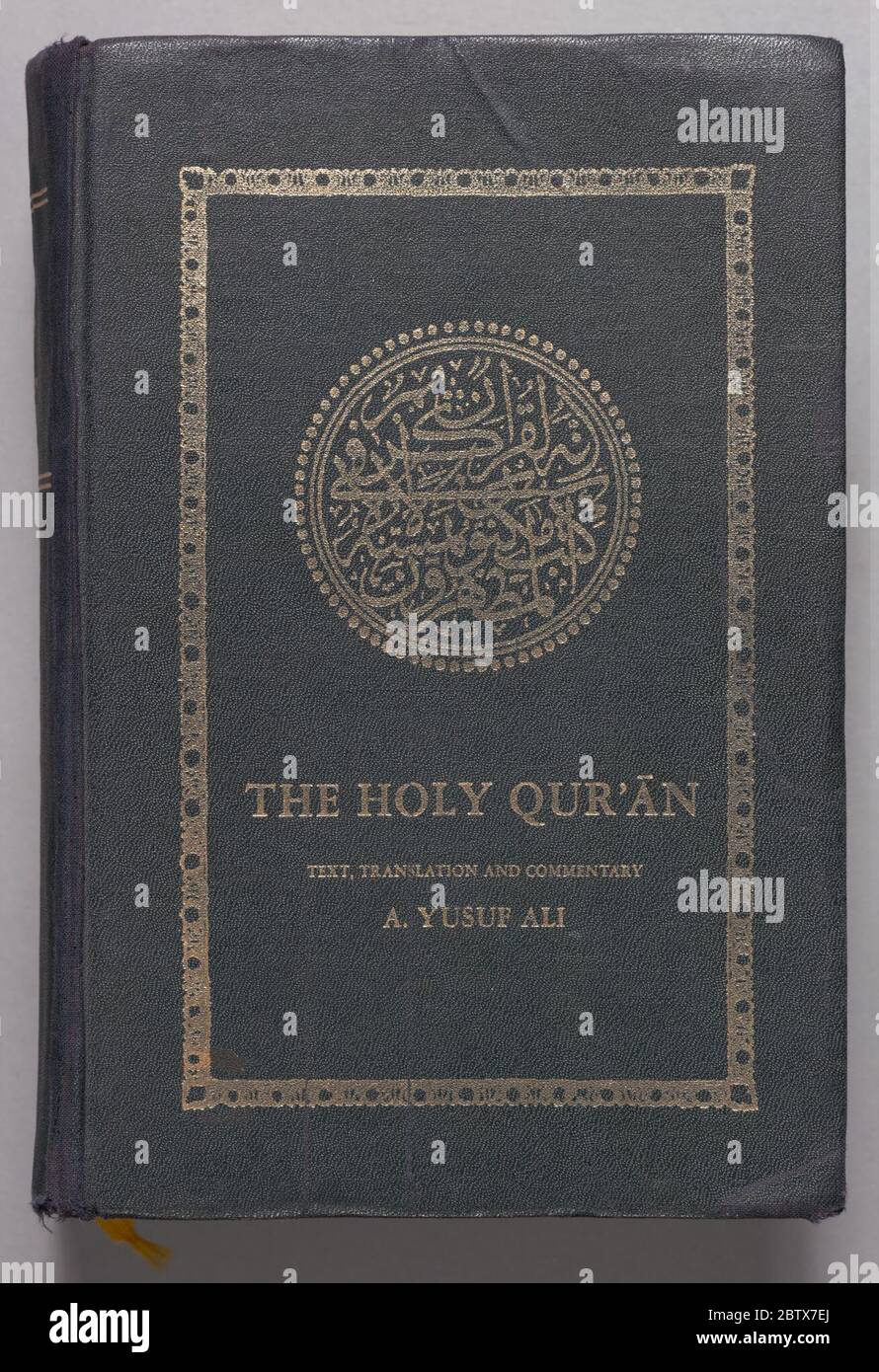 The Glorious Quran. This Qur'an (2015.133.2) is a thick hard-backed book  with a black cloth cover imprinted with gold inked letters and designs. The  front cover features a calligraphic circular design at