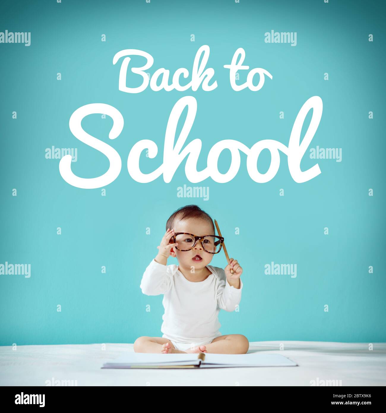 Little baby and blackboard with 'back to school' on background, School concept Stock Photo