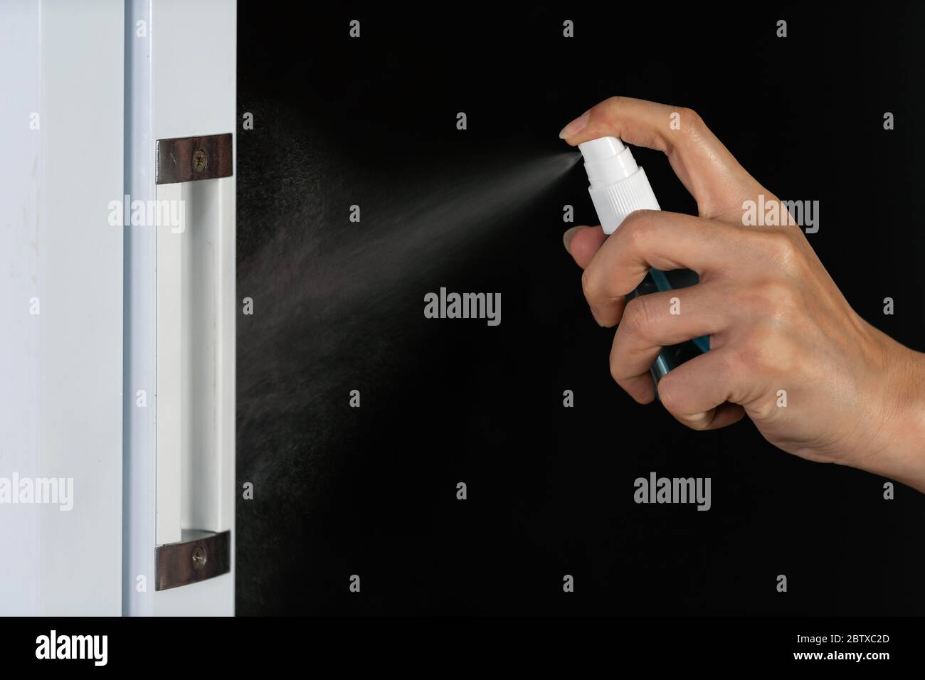 hand spraying alcohol to cleaning door knob for protect from infection