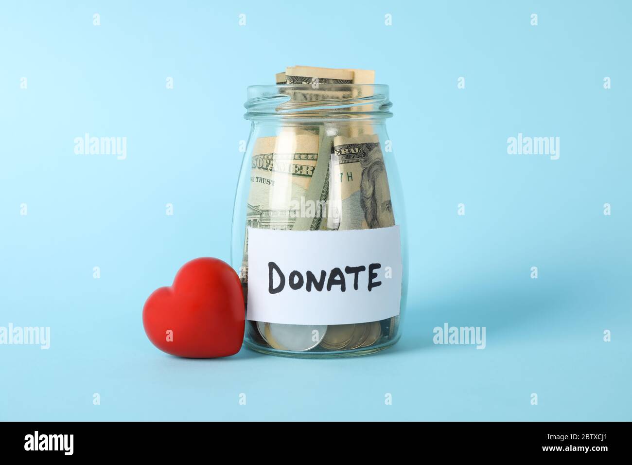 Glass jar with text Donate and heart on blue background Stock Photo Alamy