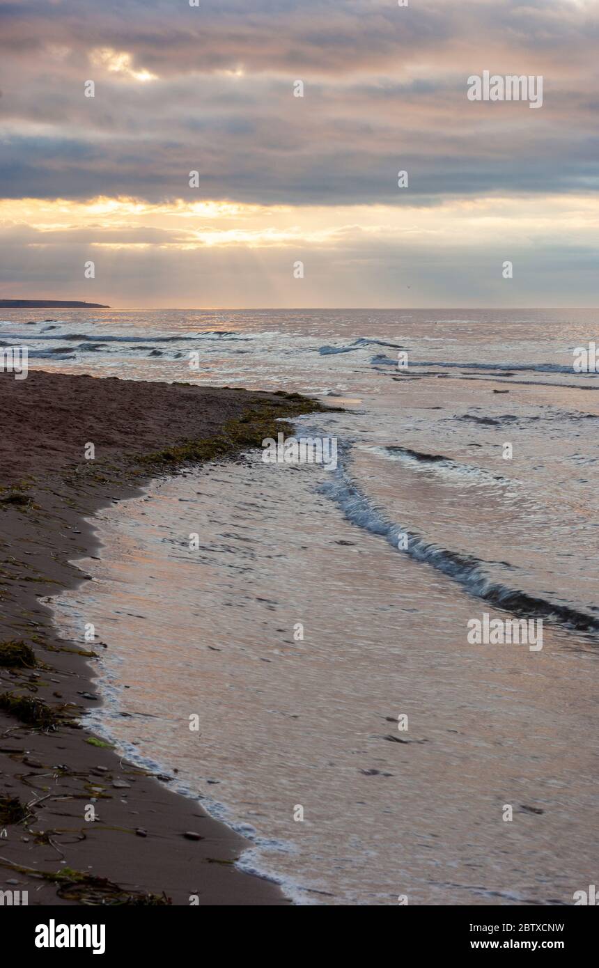 Dramatic sunset at Cavendish Beach, PEI National Park, Canada. Sunbeams
