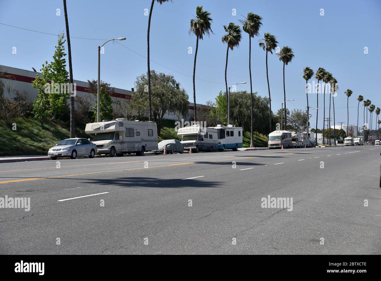 Los Angeles, CA/USA May 2, 2020 Motorhomes line street in south central Los Angeles as people