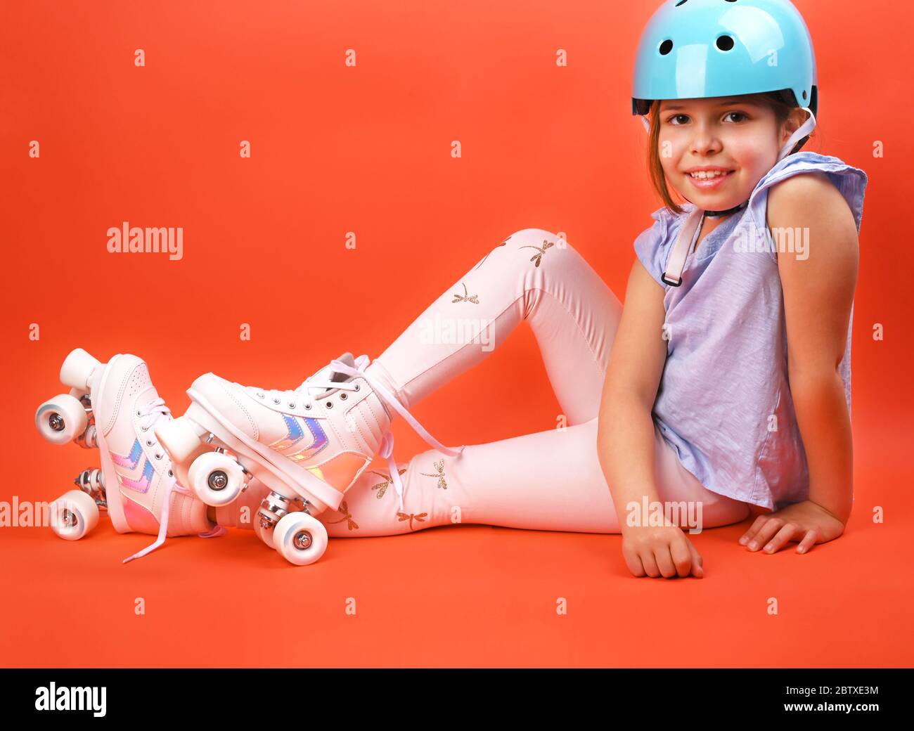 A small child with roller skates and a blue helmet demonstrates