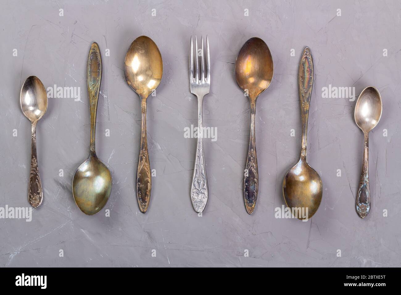Antique cutlery laid out on a gray background Stock Photo