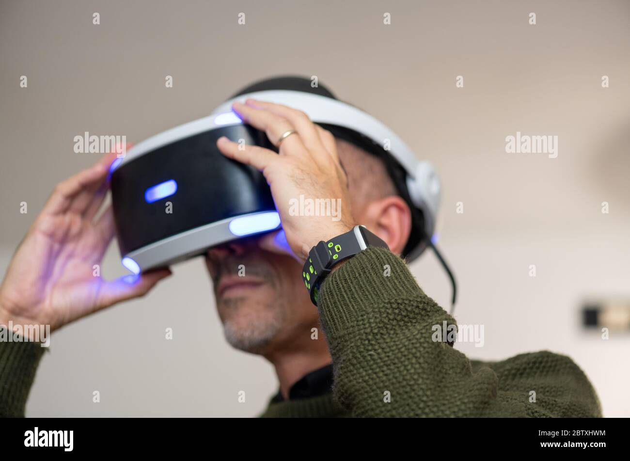 Man having fun with virtual reality, using VR glasses at home. Stock Photo