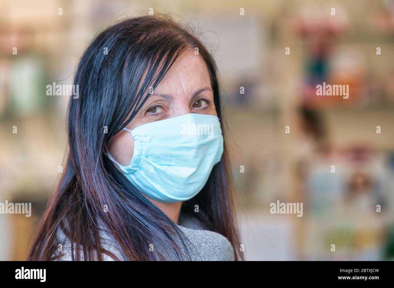 Woman wearing mask inside a local pharmacy. Stock Photo