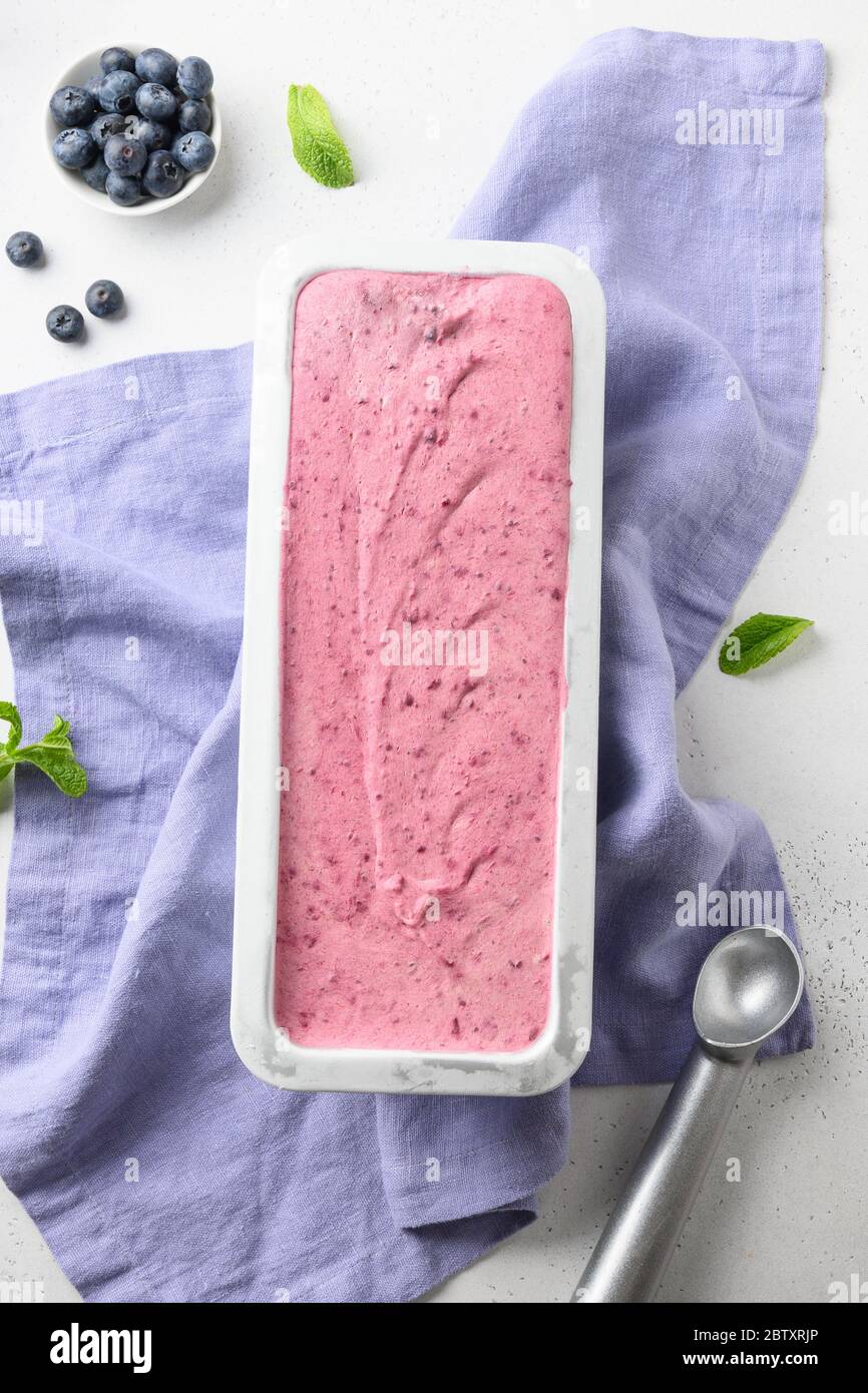 Homemade berries ice cream in metal container on white background. View from above. Clean eating