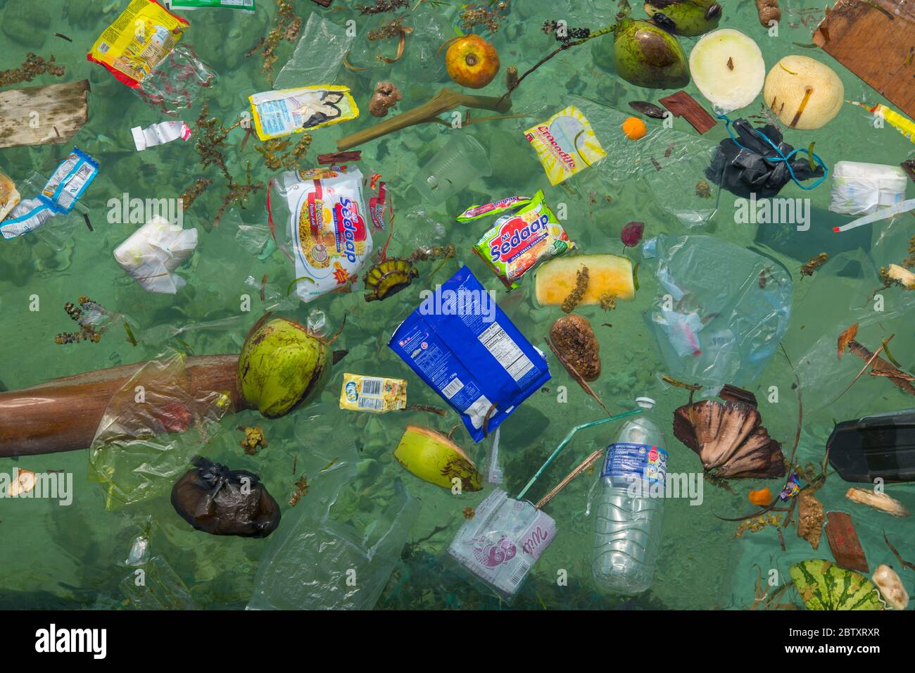 Plastic trash and pollution floating in the sea off the beach at Mabul Island, Sabah, Borneo, Malaysia. Stock Photo