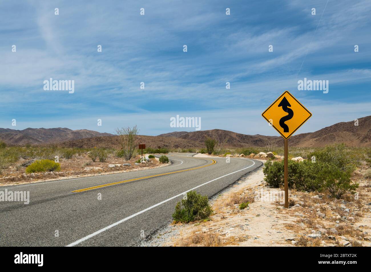 A road sign on a road through the desert in Joshua Tree National Park, California, USA. Stock Photo