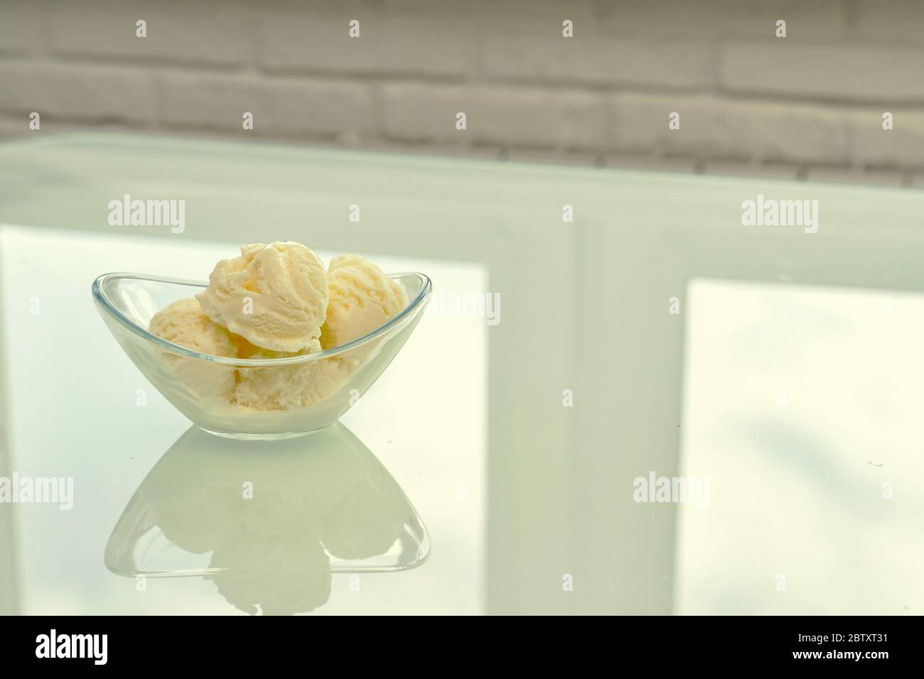 bowl with vanilla ice cream stand t in the kitchen on a bright table ...