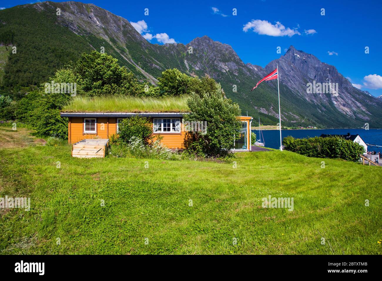 Picturesque scene of Urke village and Hjorundfjorden fjord, Norway. Drammatic sky and gloomy mountains. Landscape photography Stock Photo