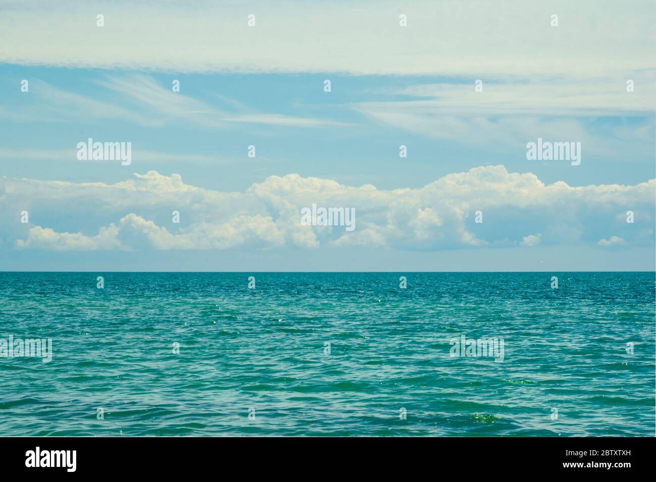 Blue sky with clouds over blue sea Stock Photo - Alamy