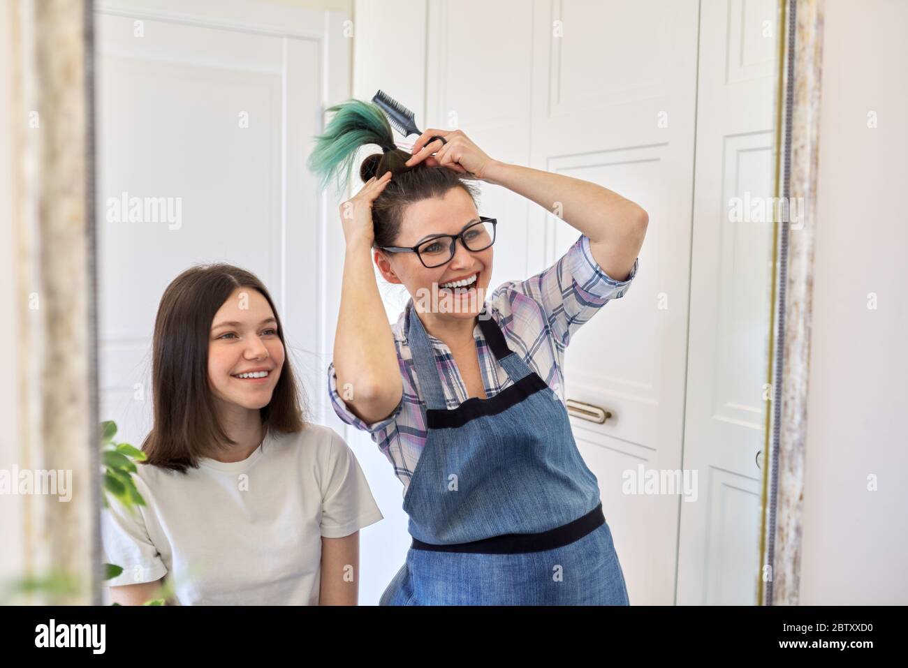 Haircut at home, mom cuts daughters hair, mother shows cut colored hair  Stock Photo - Alamy
