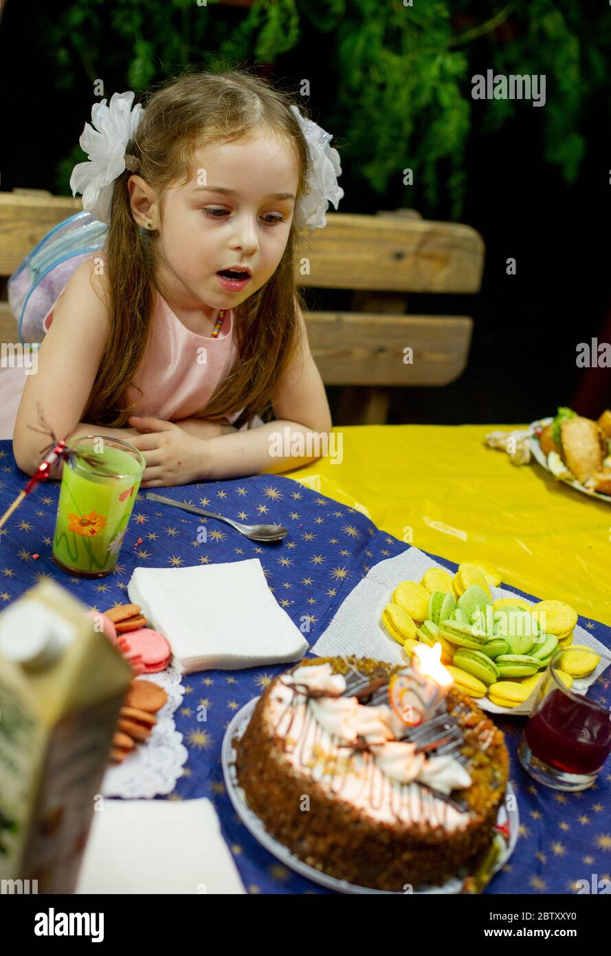 Laughing kid girl 56 year old eating birthday. Childhood. Girl 5 years