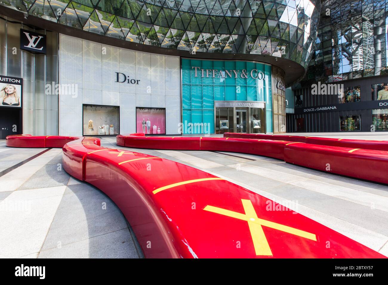 Long red bench seatings with a cross of no sitting to indicate safe