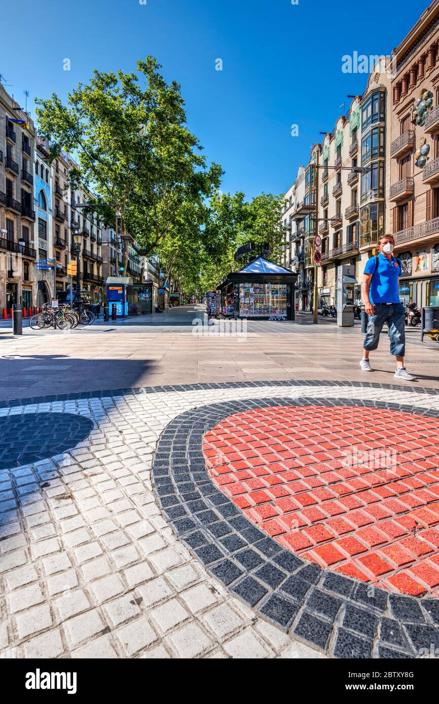Man wearing a surgical mask walking in a deserted Rambla street during covid-19 pandemic, Barcelona, Catalonia, Spain Stock Photo