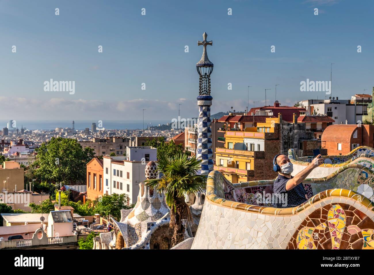 Man wearing surgical mask taking a selfie at Park Guell, Barcelona, Catalonia, Spain Stock Photo