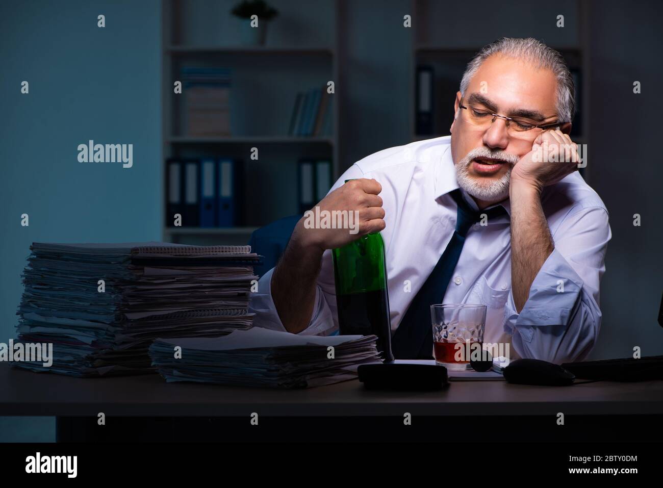 Old employee working late in the office Stock Photo