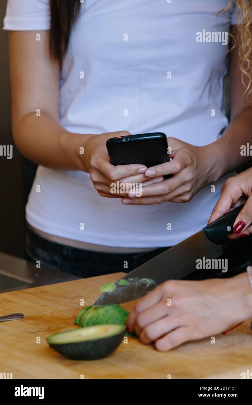 Vertical photo of the detail of a girl's hands using a mobile phone in ...