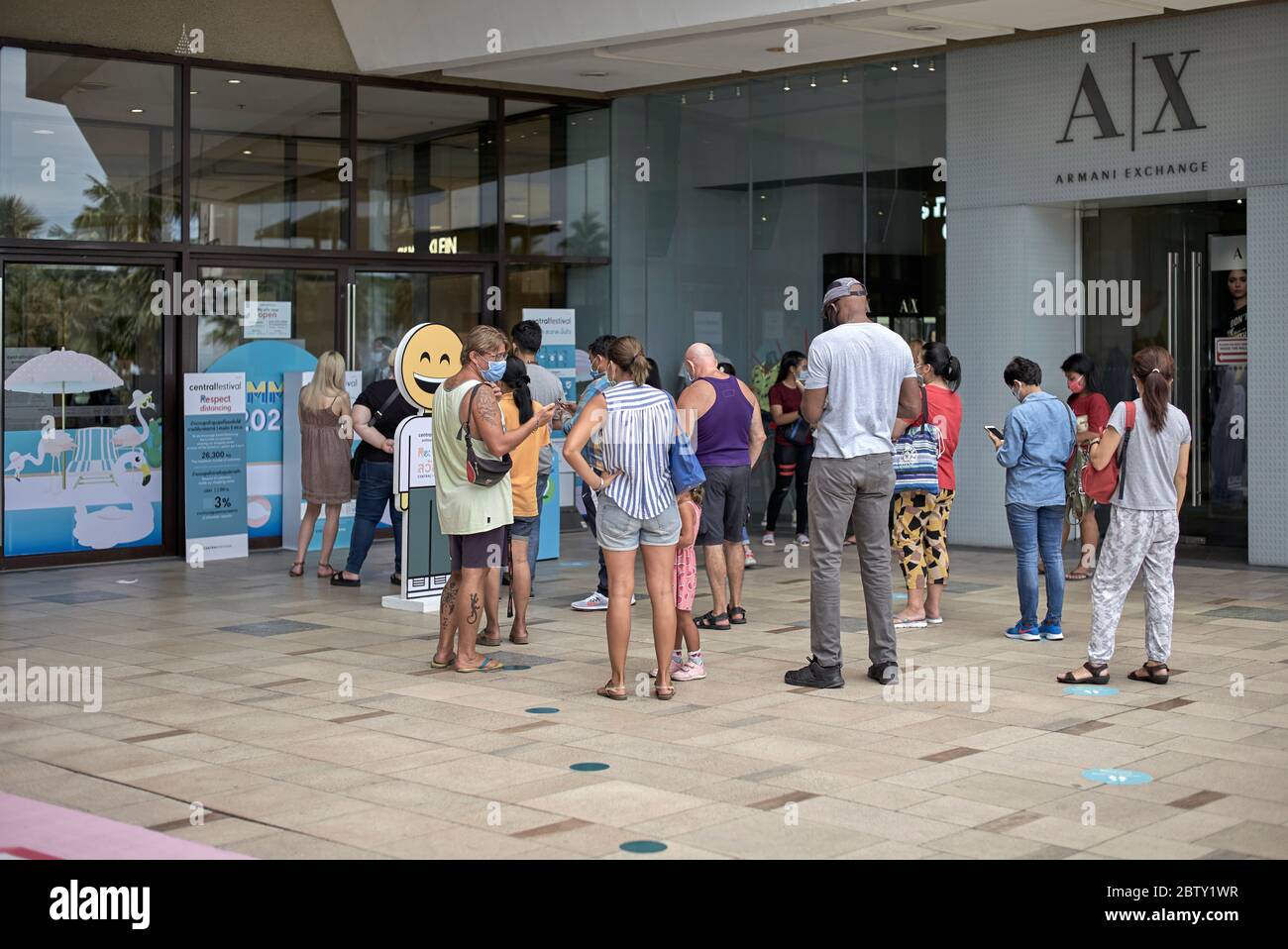 Social distancing failure. Covid-19 safety ignored as shoppers queue outside a shopping mall entrance. Stock Photo
