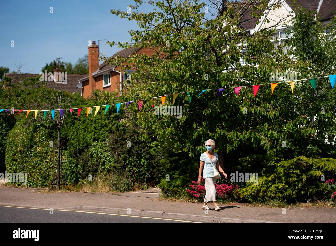 Wollaston High Street, where artist Luke Perry has hung bunting, with messages of support for neighbours and key workers, to create a 500 metre corridor of colour through the West Midlands village. Mr Perry asked local residents and shopkeepers to submit designs and messages, which he then hand painted and stitched onto bunting with the help of volunteers. Stock Photo